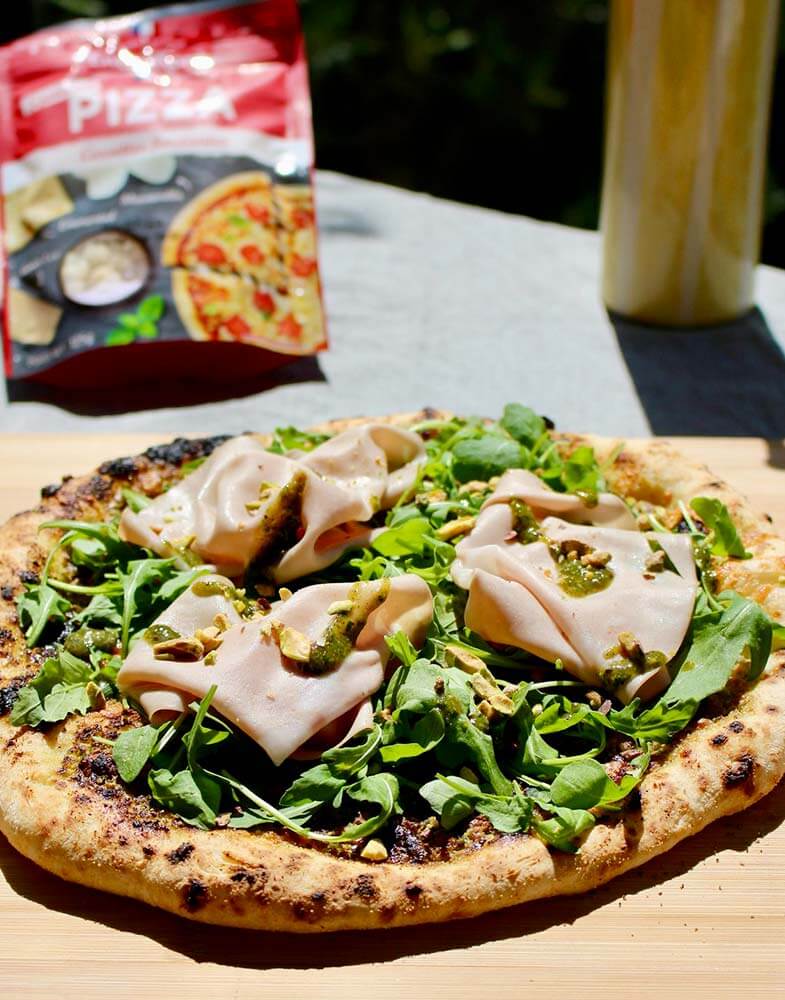Pizza pesto de pistache, roquette, mortadelle et Spécial Pizza Entremont